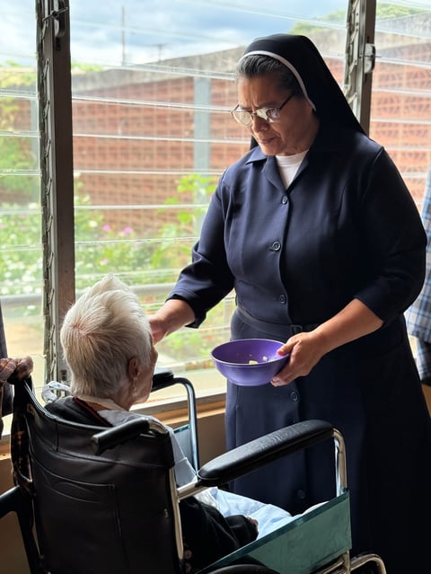 Hermana sirviendo alimento a residente